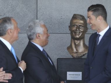 Portuguese president Marcelo Rebelo de Sousa, left, Portuguese PM Antonio Costa, 2nd left and Real Madrid's Cristiano Ronaldo stand next to a bust of the player at the Madeira Airport. AP Photo
