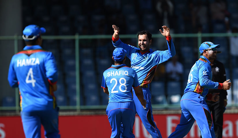 Afghanistan's Mohammad Nabi(C)celebrates the wicket of England's captain Eoin Morgan during the World T20. AFP