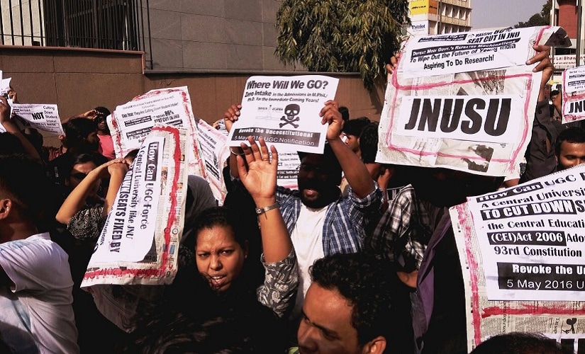 JNU students protesting massive seat cut in MPhil and PhD courses on Friday staged a protest outside the UGC building. News18