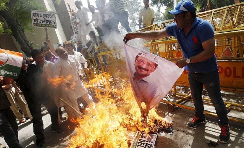 An activist of the youth wing of India's opposition Congress party burns a banner of Arvind Kejriwal, chief of Aam Aadmi (Common Man) Party (AAP) and Chief Minister of Delhi, during a protest over the suicide by a farmer at a rally on Wednesday, in New Delhi April 23, 2015. A farmer hanged himself from a tree during a political rally organised by the Aam Aadmi Party (AAP) in New Delhi on Wednesday, in what appeared to be a desperate protest against the hardship felt by many people scratching a living in rural India. REUTERS/Adnan Abidi - RTX19Y1M