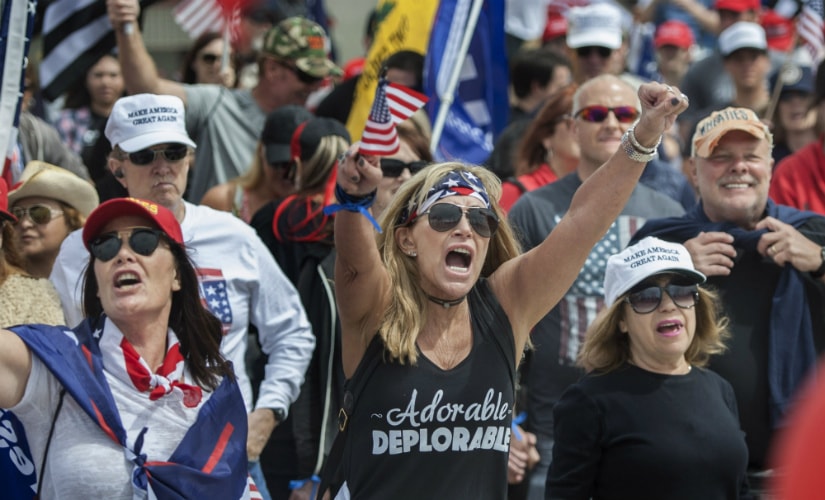 Wearing her "Adorable Deplorable" tee, Deanne Payn, center, with Sheila Ponce, left, take part in a pro-President Donald Trump rally in Huntington Beach, Calif., on Saturday, March 25, 2017.