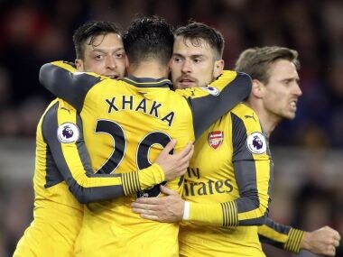 Arsenal's Mesut Ozil, left, celebrates with teammates after scoring. AP