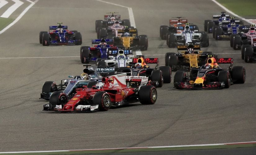 Ferrari driver Sebastian Vettel, foreground, overtakes Mercedes driver Lewis Hamilton, 2nd left, entering the first curve at the start of the Bahrain Grand Prix. AP