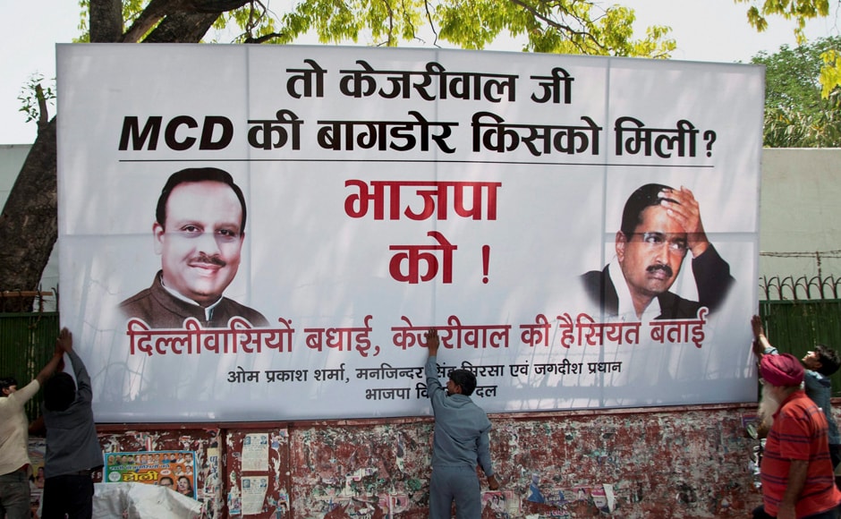 Workers put up a hoarding outside Delhi BJP headquarters in New Delhi on Wednesday. PTI Workers put up a hoarding outside Delhi BJP headquarters in New Delhi on Wednesday. PTI
