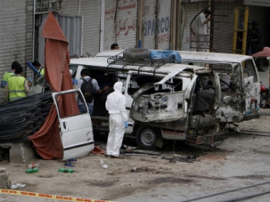 Pakistani investigators examine damage vehicles at the site of suicide bombing in Lahore, Pakistan, Wednesday on Wednesday. AP