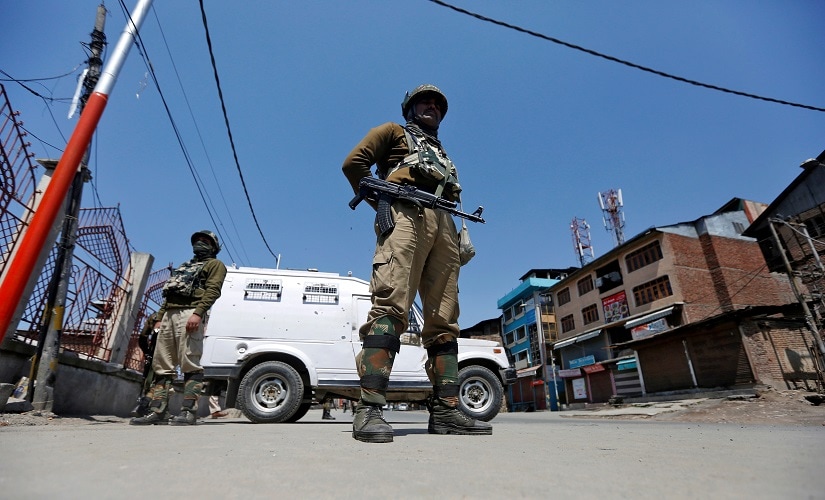 Security forces in Kashmir guard a deserted street during restrictions in downtown Srinagar. Reuters