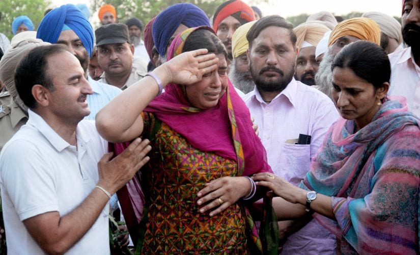 Wife of a CRPF martyr saluting her husband's body at his funeral in a village in Punjab. PTI