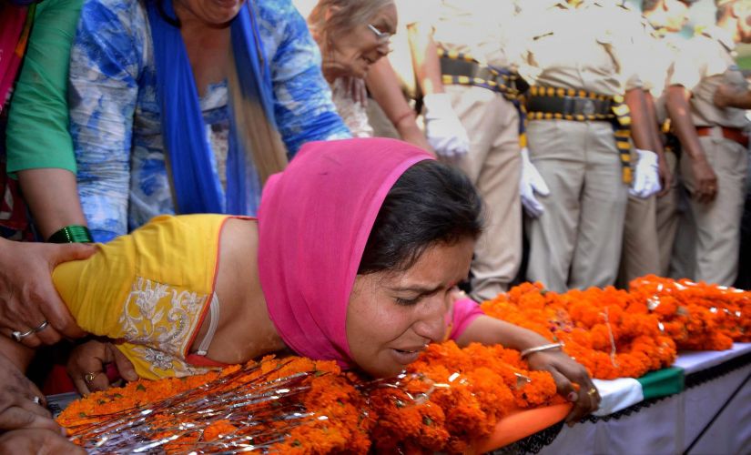 Wife of of CRPF martyr Surender Thakur mourns at her husband's funeral at his native village Ner Chowk Mandi on Tuesday. PTI