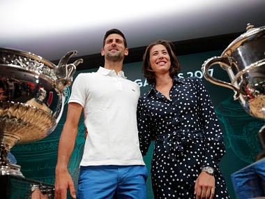 Defending champions Serbia's Novak Djokovic and Spain's Garbine Muguruza pose in front of the cups during the draw of the French Open. AP