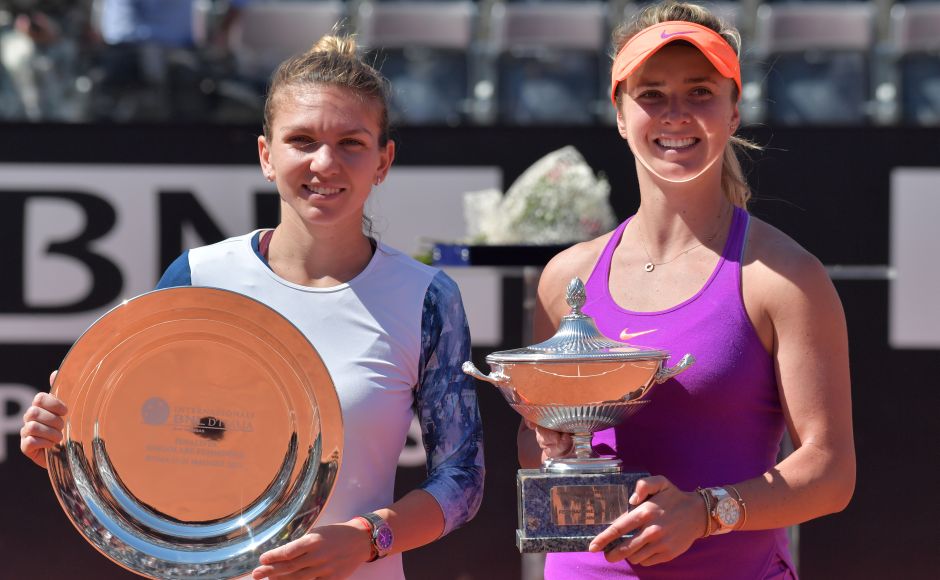 Elina Svitolina (R) of Ukraine poses with the trophy after winning the WTA Tennis Open final against Simona Halep (L) of Romania, on May 21, 2017 at the Foro Italico in Rome. Ukraine's Elina Svitolina stunned Romanian favourite Simona Halep 4-6, 7-5, 6-1 to win the WTA event at the Rome Masters today. / AFP PHOTO / Tiziana FABI