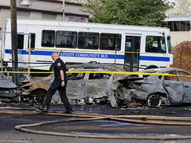 A police officer walks near the site of a deadly small plane crash near Teterboro Airport in Carlstadt, NJ, just west of New York City, Monday, May 15, 2017. Police said a Learjet 35 crashed into a building near the airport sparking a fire that sent thick, black smoke spewing into the air. AP