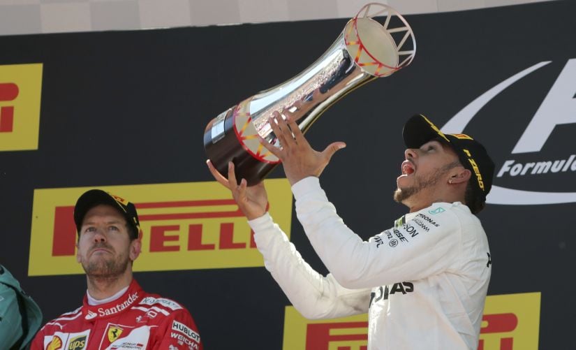 Mercedes driver Lewis Hamilton celebrates on the podium after winning the Spanish Grand Prix. AP