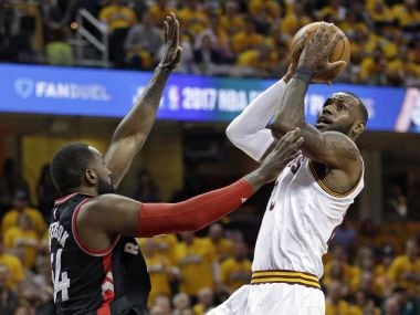 Cleveland Cavaliers' LeBron James, right, drives to the basket against Toronto Raptors. AP