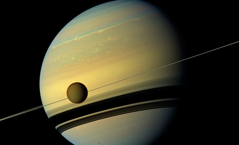Titan, Saturn's largest moon appears before the planet as it undergoes seasonal changes in this natural color view from NASA's Cassini spacecraft in this handout released by NASA August 29, 2012. Reuters