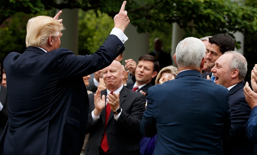 President Donald Trump pumps his hands to GOP House members after the House pushed through a health care bill. AP