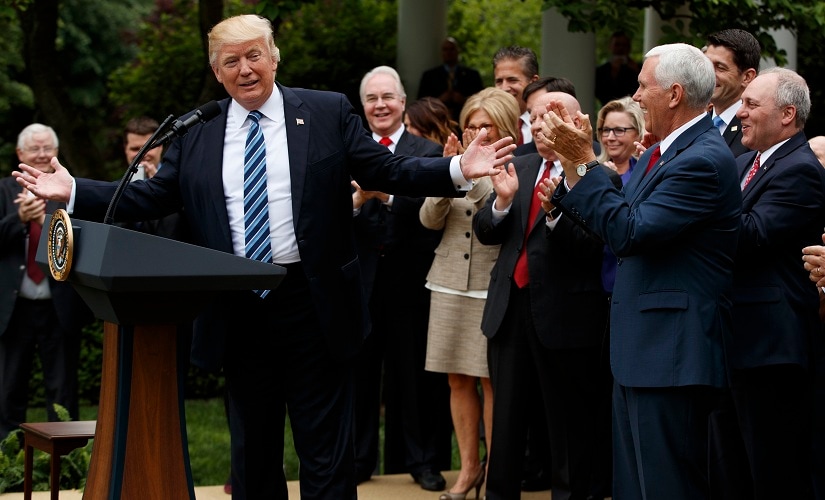 President Donald Trump, accompanied by GOP House members, speaks in the Rose Garden of the White House in Washington on Thursday. AP