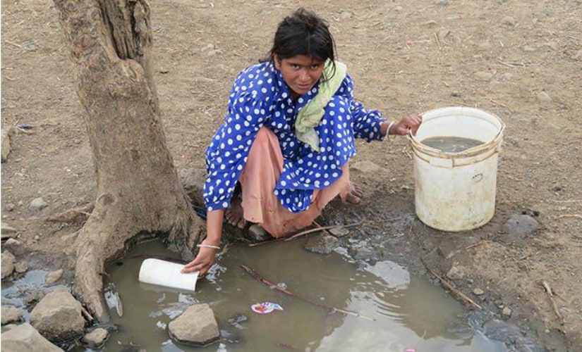 A young woman fills her bucket with dirty water fearing that the handpump might give in anytime. Photo courtesy: Parth MN