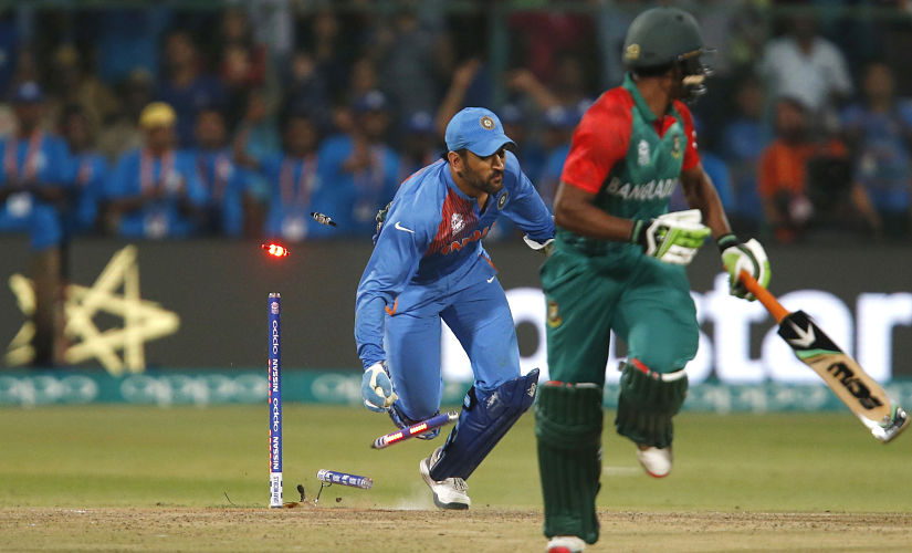 India's captain MS Dhoni dashes to catch Bangladesh's Mustafizur Rahman just short. India win by 1 run to progress into the knockouts. Reuters