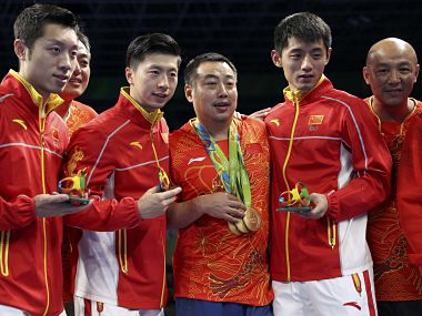 2016 Rio Olympics - Table Tennis - Men's Team - Victory Ceremony - Riocentro - Pavilion 3 - Rio de Janeiro, Brazil - 17/08/2016. Gold medallists Ma Long (CHN) of China, Xu Xin (CHN) of China and Zhang Jike (CHN) of China pose with their coach Liu Guoliang and other members of their team on the podium. REUTERS/Alkis Konstantinidis FOR EDITORIAL USE ONLY. NOT FOR SALE FOR MARKETING OR ADVERTISING CAMPAIGNS. - RTX2MG2C
