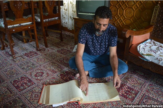 Tariq Ahmad Patloo showing the entries of foreign guests during 1980s from an old log book of his house-boat New Sea Palace.