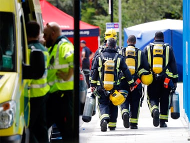 Emergency services attend the scene of the high-rise apartment building where a massive fire raged overnight, in London, Wednesday. AP