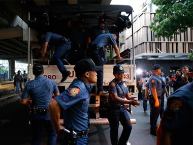 Police alight from their vehicle outside a hotel at the Resorts World Manila complex on early Friday after a gunman killed 37 people. AP