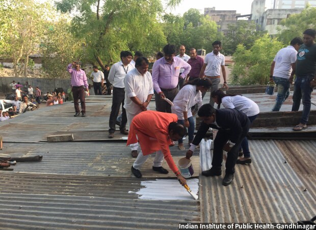 In 2014, the Ahmedabad Municipal Corporation pioneered South Asia’s first Heat Action Plan, which among other measures included an initiative to ask paint companies to donate white paint to coat the roof of poor people’s houses. White-painted roofs reflect more sunlight, which helps keep interiors cool. Of the 3,000 roofs targeted to be painted, 2,800 roofs have actually been painted, with the first roof being painted by the mayor Gautam Shah (in orange) and other office bearers of the corporation with community youth.