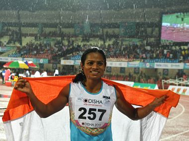 (FILES) In this photograph taken on July 7, 2017, India's Dutee Chand celebrates after placing third in the women's 100m event at the 22nd Asian Athletics Championships at Kalinga Stadium in Bhubaneswar. Indian sprinter Dutee Chand vowed July 11 to fight any efforts to bar her from the sport, after new research showed runners born with high testosterone levels enjoy a "significant competitive advantage". The 21-year-old was banned after being diagnosed in 2014 with hyperandrogenism -- a condition that causes high natural levels of the hormone in women. / AFP PHOTO / Dibyangshu SARKAR