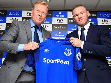 England soccer star Wayne Rooney, right, holds an Everton shirt with his new manager Ronald Koeman during the press conference at Goodison Park, Liverpool, England Monday July 10, 2017. Rooney returned to his original club Everton from Manchester United. (Nigel French/PA via AP)