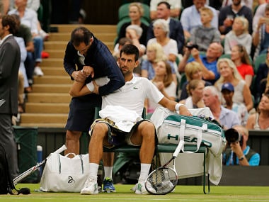 Serbia's Novak Djokovic receives treatment from a trainer during a break in his Men's Singles Match against Adrian Mannarino of France on day eight at the Wimbledon Tennis Championships in London Tuesday, July 11, 2017. (AP Photo/Alastair Grant)