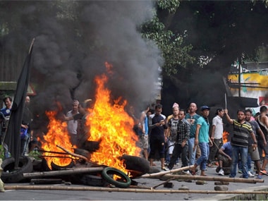 GJM Youth wings members raise slogans after burning articles as they clash with police during Khukrai rally in Sukna, near Siliguri on Saturday. PTI