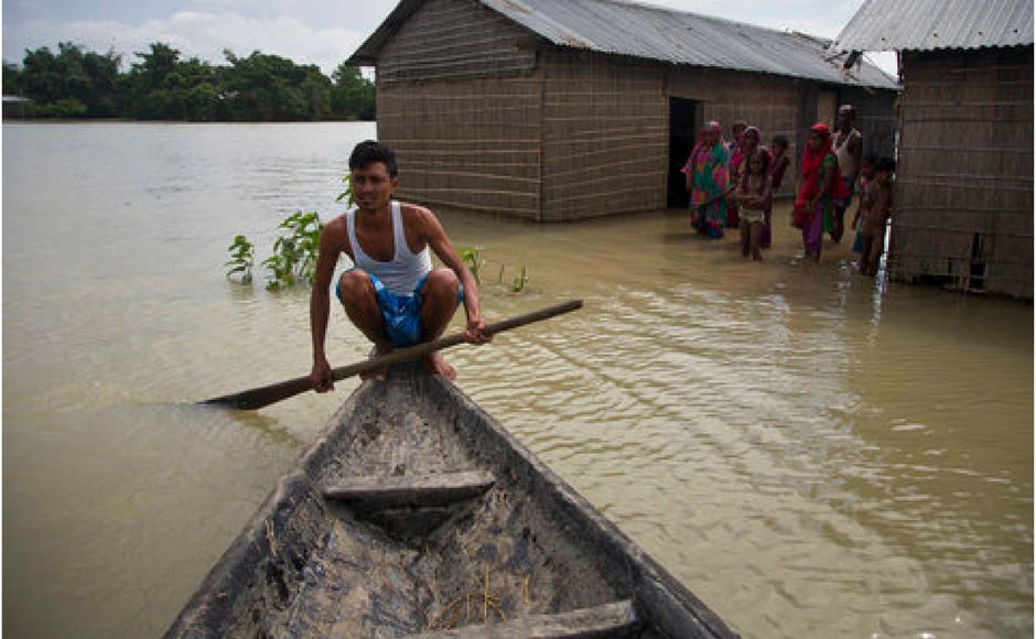 A man paddles a boat near submerged houses at Burgaon, 80 kilometres east of Guwahati in Assam. AP A man paddles a boat near submerged houses at Burgaon, 80 kilometres east of Guwahati in Assam. AP