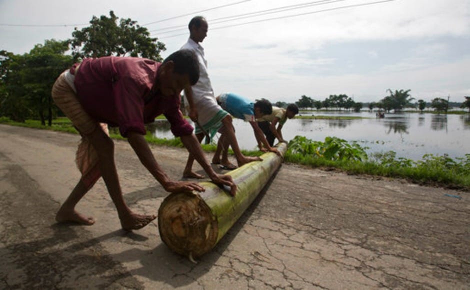 Villagers push the trunk of a banana plant as they prepare to make a banana raft to cross flood waters in Mayong village, east of Guwahati in Assam. AP Villagers push the trunk of a banana plant as they prepare to make a banana raft to cross flood waters in Mayong village, east of Guwahati in Assam. AP