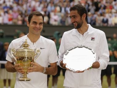 Roger Federer, left, holds the winners trophy alongside Marin Cilic with the runners up plate. AP