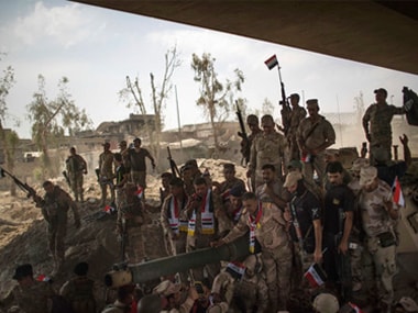 Iraqi Army soldiers gather to celebrate their gains as their fight against Islamic State militants continues in the Old City of Mosul, Iraq, on Sunday. AP