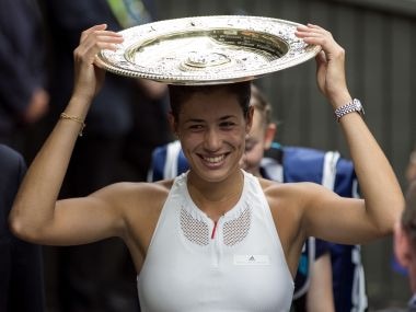 Spain's Garbine Muguruza holds the trophy as she leaves the court after defeating Venus Williams of the United States in the Women's Singles final match on day twelve at the Wimbledon Tennis Championships in London Saturday, July 15, 2017. (Steven Paston/PA via AP)
