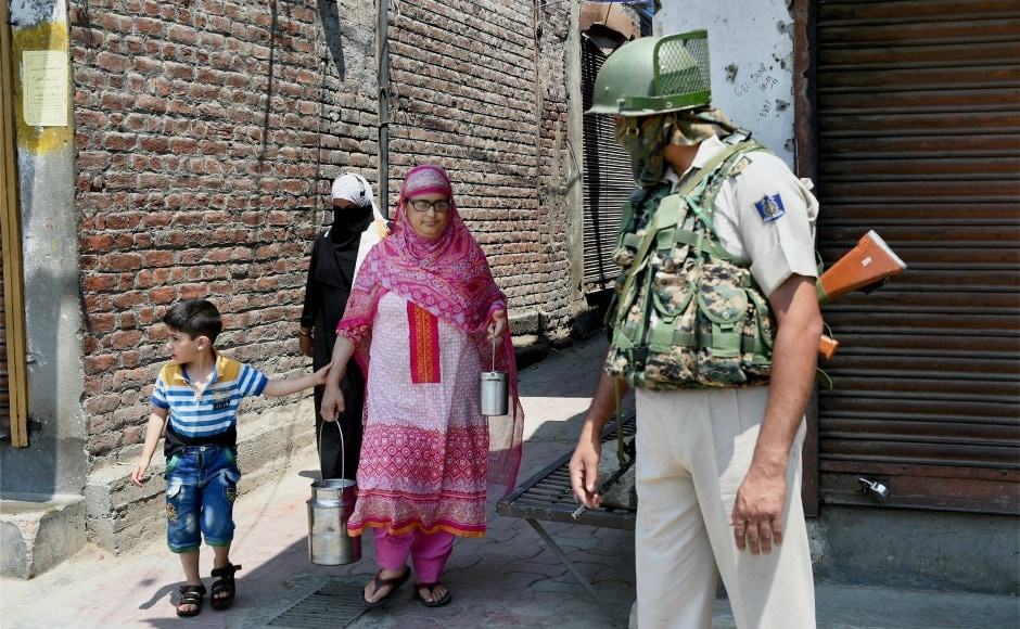 A woman with her child walks past a security personnel during a strike in Srinagar on Sunday. PTI A woman with her child walks past a security personnel during a strike in Srinagar on Sunday. PTI
