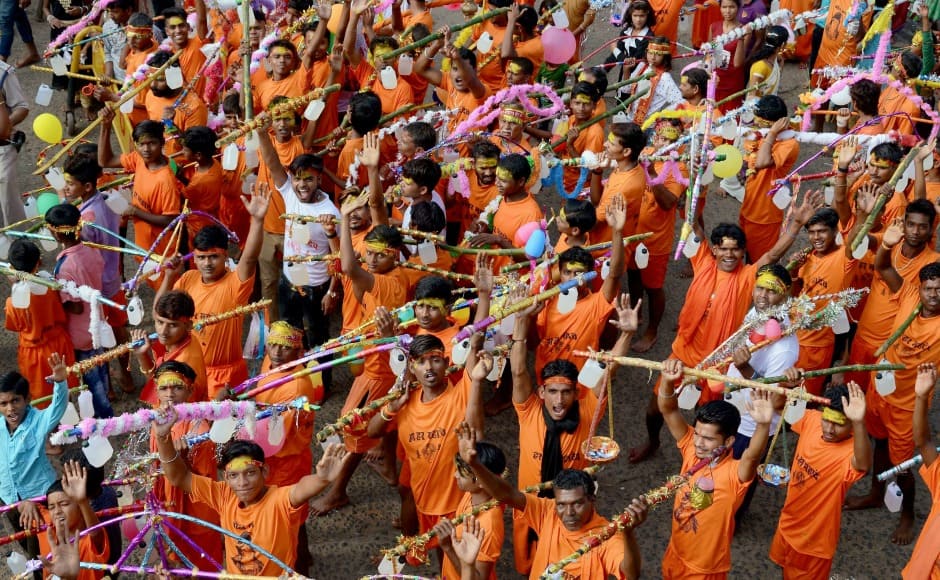 Kawariyas carrying the holy water balanced on their shoulders during the month of Sawan at Gwarighat in Jabalpur on Monday. PTI