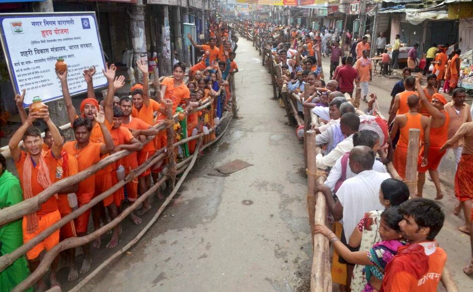 Devotees wait in long queue to worship at Kashi Vishwanath temple during Shravan in Varanasi on Monday. PTI