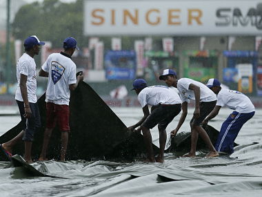 Ground workers pull the covers to cover the ground as the match was stopped due to rain, on the first day of third and final test cricket match between India and Sri Lanka in Colombo August 28, 2015. REUTERS/Dinuka Liyanawatte - RTX1PZJW