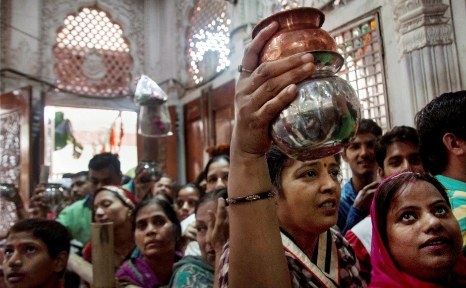 Hindu devotees stand in a long queue at Gauri Shankar temple, on beginning of Sawan month, in New Delhi on Monday. PTI
