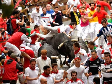Revellers run as others fall on Miura’s fighting bulls during the running of the bulls at the San Fermin Festival, in Pamplona. AP