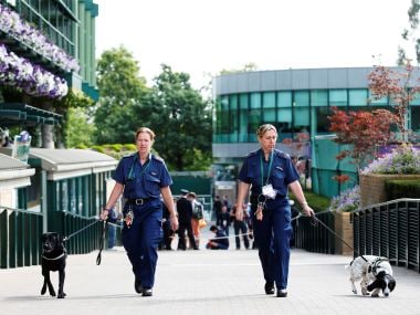 ecurity staff with dogs before the start of play at Wimbledon. Reuters