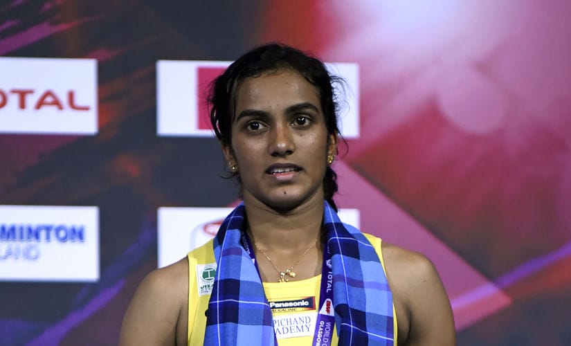 India's Sindhu Pusarla poses with her silver medal on the podium after her defeat to Japan's Nozomi Okuhara in their women's singles final match during the 2017 BWF World Championships of badminton at Emirates Arena in Glasgow on August 27, 2017. / AFP PHOTO / ANDY BUCHANAN