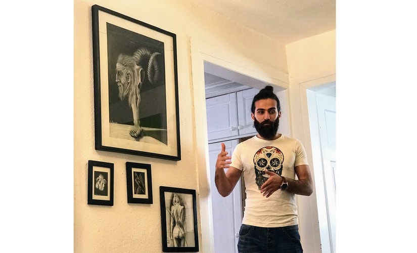 Akhil Amre with his charcoal art work behind him. Image courtesy: Nimish Sawant