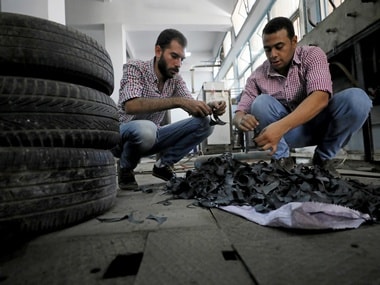 Engineering students, Mostafa Saeed Ali and Mohamed Amr cut up car tires in Cairo. Reuters.