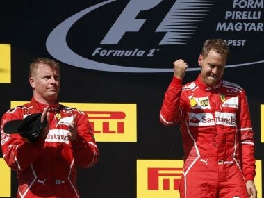 Second placed Ferrari driver Kimi Raikkonen of Finland' left, applauds as teammate Sebastian Vettel of Germany celebrates after winning the Hungarian Formula One Grand Prix, at the Hungaroring racetrack in Mogyorod, northeast of Budapest, Sunday, July 30, 2017. (AP Photo/Darko Bandic)