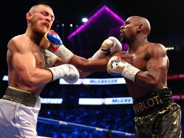 Floyd Mayweather lands a hit against Conor McGregor during their boxing match. Reuters