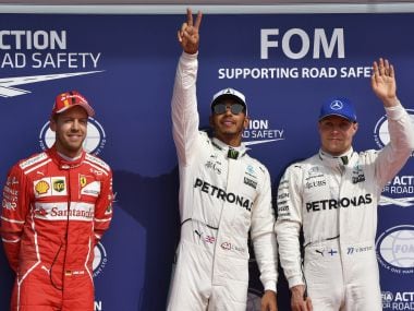 Mercedes driver Lewis Hamilton of Britain, center, stands on the podium with Mercedes driver Valtteri Bottas of Finland, right, and Ferrari driver Sebastian Vettel of Germany, left, after the qualifying session ahead of the Belgian Formula One Grand Prix in Spa-Francorchamps, Belgium, Saturday, Aug. 26, 2017. Lewis Hamilton has secured pole position for the Belgian Grand Prix, equalling Michael Schumacher's record of 68 career poles. (AP Photo/Geert Vanden Wijngaert)