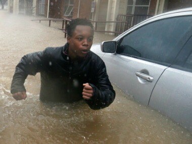 A young man fights the current from the overflow of Buffalo Bayou as he makes his way through floodwaters. AP
